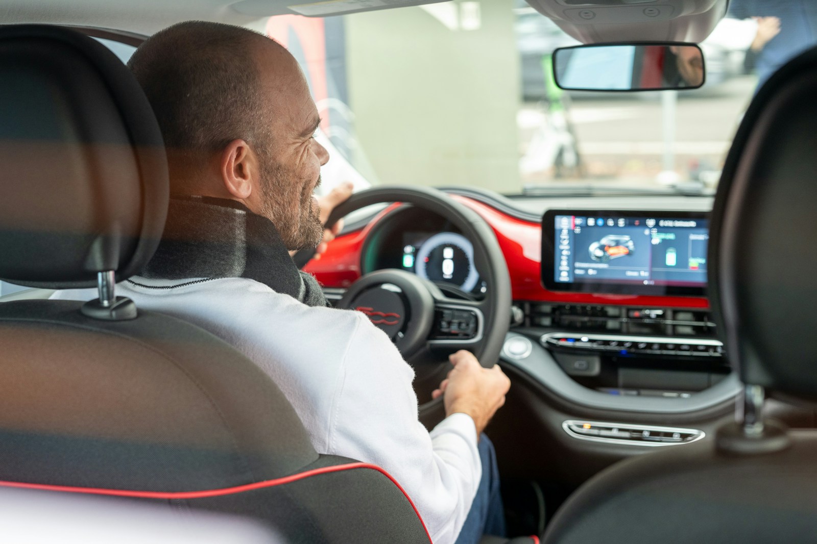 A man driving a car with a steering wheel, auto